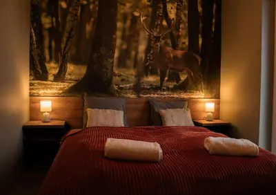 a bedroom with a bed with a picture of a deer at Domki Natura Zator in Graboszyce