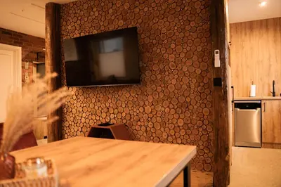a kitchen with a table and a television on a wall at Domki Natura Zator in Graboszyce