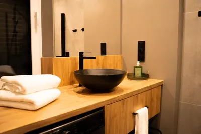 a bowl on top of a wooden counter with towels at Domki Natura Zator in Graboszyce