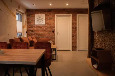 a living room with a brick wall and a table and chairs at Domki Natura Zator in Graboszyce