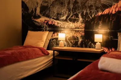a bedroom with two beds and two lamps on tables at Domki Natura Zator in Graboszyce