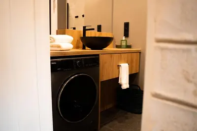 a bathroom with a washing machine and a sink at Domki Natura Zator in Graboszyce