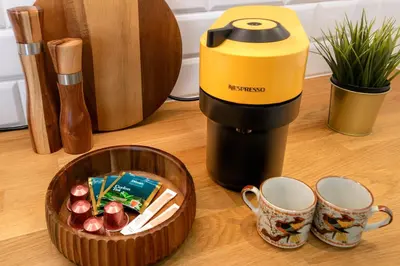 a coffee maker and a bowl of apples on a counter at Malila Premium Apartments Szczepański Square in Kraków