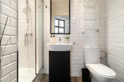 a white bathroom with a sink and a toilet at Malila Premium Apartments Szczepański Square in Kraków