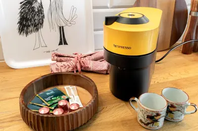 a coffee maker sitting next to a bowl of mugs at Malila Premium Apartments Szczepański Square in Kraków
