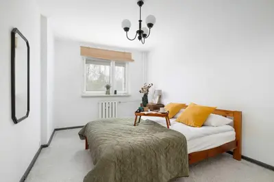 a bedroom with a bed with a table and a mirror at Cozy Apartment with Balcony in Cracow by Noclegi Renters in Kraków