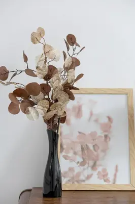 a black vase with flowers in it next to a painting at Cozy Apartment with Balcony in Cracow by Noclegi Renters in Kraków
