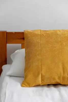 a yellow pillow sitting on top of a bed at Cozy Apartment with Balcony in Cracow by Noclegi Renters in Kraków