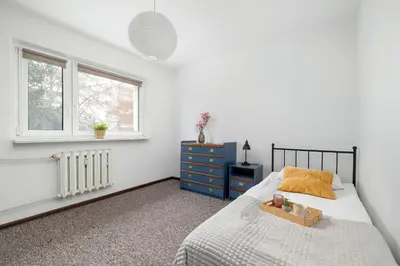 a bedroom with a bed with a blue dresser and a window at Cozy Apartment with Balcony in Cracow by Noclegi Renters in Kraków
