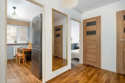 a kitchen and dining room with a mirror and a table at Cozy Apartment with Balcony in Cracow by Noclegi Renters in Kraków