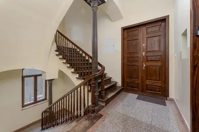 a hallway with a wooden door and a checkered floor at Cracow City Centre Apartment by BookingHost in Kraków