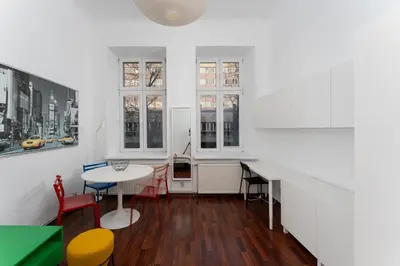 a kitchen with white cabinets and a brown door at Cracow City Centre Apartment by BookingHost in Kraków