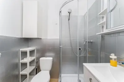 a bathroom with a shower and a washing machine at Cracow City Centre Apartment by BookingHost in Kraków