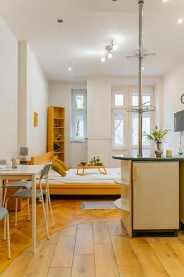 a kitchen and living room with a bed in the background at Piasek Studio - Old Town nearby - by Rentujemy in Kraków