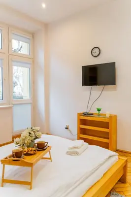 a bedroom with a bed with a tv on the wall at Piasek Studio - Old Town nearby - by Rentujemy in Kraków