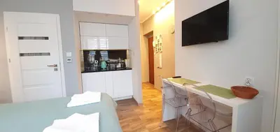 a living room with a kitchen with a table and a television at NextToNobu in Kraków