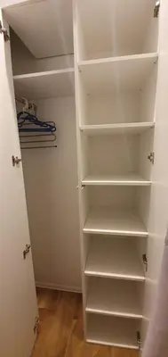 a walk in closet with white shelves at NextToNobu in Kraków