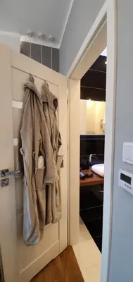 a closet with coats hanging on a door at NextToNobu in Kraków