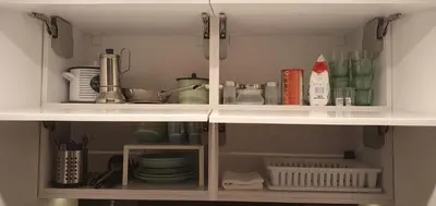 a kitchen cabinet filled with dishes and other kitchen items at NextToNobu in Kraków