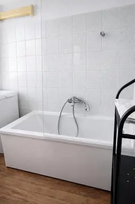 a white bath tub with a faucet in a bathroom at Urban Nest Apartments Radziwiłłowska 17 in Kraków