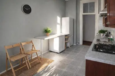 a kitchen with a white refrigerator and a chair at Urban Nest Apartments Radziwiłłowska 17 in Kraków