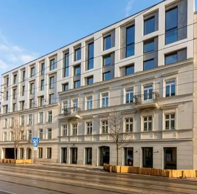 a large white building on the side of a street at Wawel Riverside Apartment free Parking in Kraków