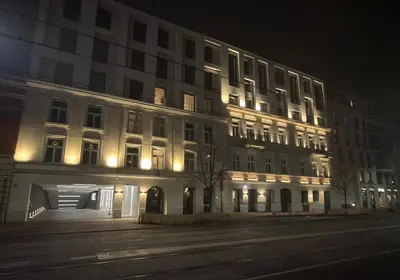a large white building with lights on it at night at Wawel Riverside Apartment free Parking in Kraków