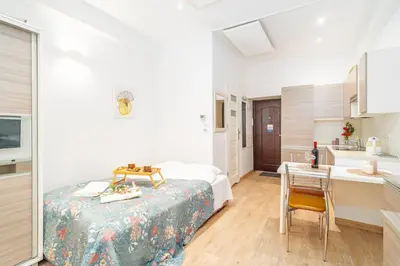 a bedroom with a bed and a table and a kitchen at Krakow Old Town Studio N1 - by Rentujemy in Kraków