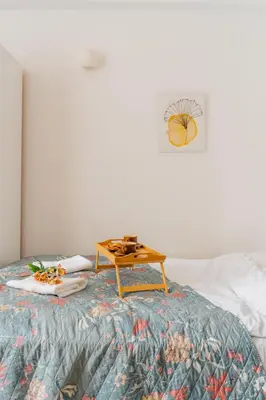 a table on a bed with a tray of food on it at Krakow Old Town Studio N1 - by Rentujemy in Kraków