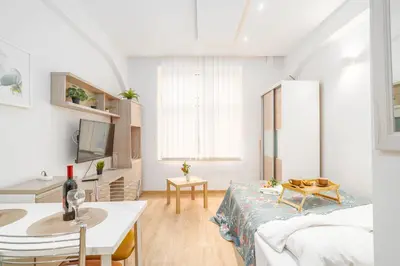 a living room with a bed and a table at Krakow Old Town Studio N1 - by Rentujemy in Kraków