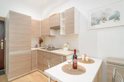 a kitchen with a table with a bottle of wine on it at Krakow Old Town Studio N1 - by Rentujemy in Kraków