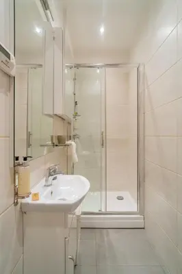 a white bathroom with a shower and a sink at Kraków Old Town Studio N2 - by Rentujemy in Kraków