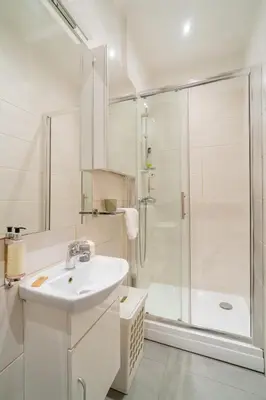 a white bathroom with a shower and a sink at Kraków Old Town Studio N2 - by Rentujemy in Kraków