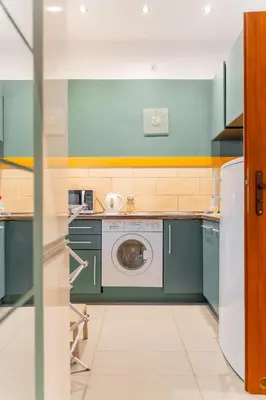a green kitchen with a washing machine in it at Kraków Old Town Studio N2 - by Rentujemy in Kraków