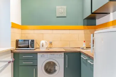 a kitchen with a washing machine and a microwave at Kraków Old Town Studio N2 - by Rentujemy in Kraków
