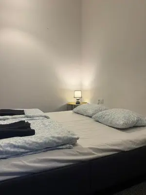 a bed with two pillows and a lamp on a table at Lanzo ST 48 in Kraków