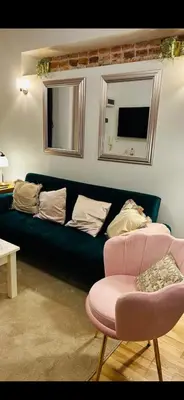 a living room with a blue couch and a pink chair at Old town Krakow in Kraków