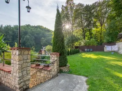 a backyard with a stone wall and a bench at Noclegi pod Sosnowym Drzewem in Pieskowa Skała
