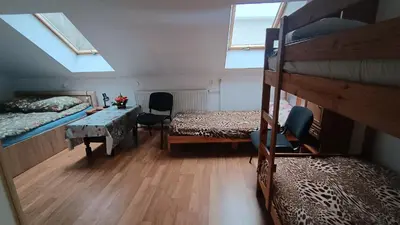 a room with two bunk beds and a table and a desk at Noclegi pod Sosnowym Drzewem in Pieskowa Skała