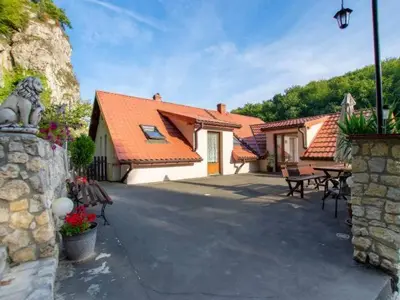 a house with a stone wall and a patio at Noclegi pod Sosnowym Drzewem in Pieskowa Skała