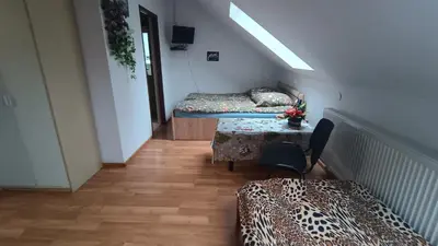 a room with two beds and a table with a tableablish at Noclegi pod Sosnowym Drzewem in Pieskowa Skała