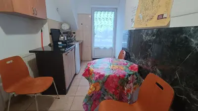 a kitchen with a table with a flowered table cloth at Noclegi pod Sosnowym Drzewem in Pieskowa Skała