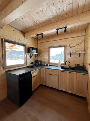a kitchen with wooden cabinets and a black counter top at Domki na granicy - Kurów in Kurów