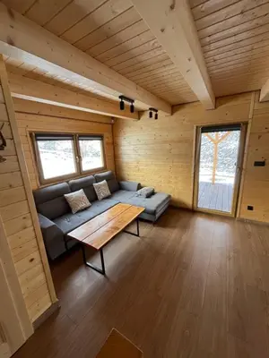 a living room in a log cabin with a couch and a table at Domki na granicy - Kurów in Kurów