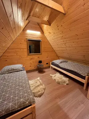 a room with two beds in a wooden cabin at Domki na granicy - Kurów in Kurów