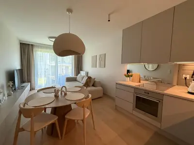 a kitchen and a living room with a table and chairs at Jasna Elegancja in Kraków
