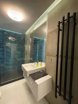 a bathroom with a white sink and a mirror at Apartament Rondo in Kraków