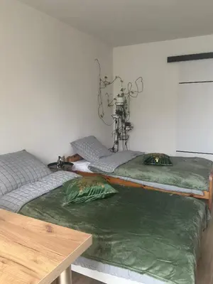 two twin beds in a room with a table at Stacja kolejowa Kraków Płaszów in Kraków