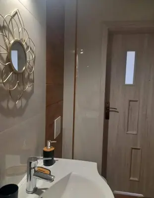 a bathroom with a sink and a mirror and a door at Stacja kolejowa Kraków Płaszów in Kraków