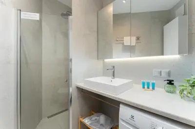a white bathroom with a sink and a shower at Cracow Novum Apartment #533 by BookingHost in Kraków
